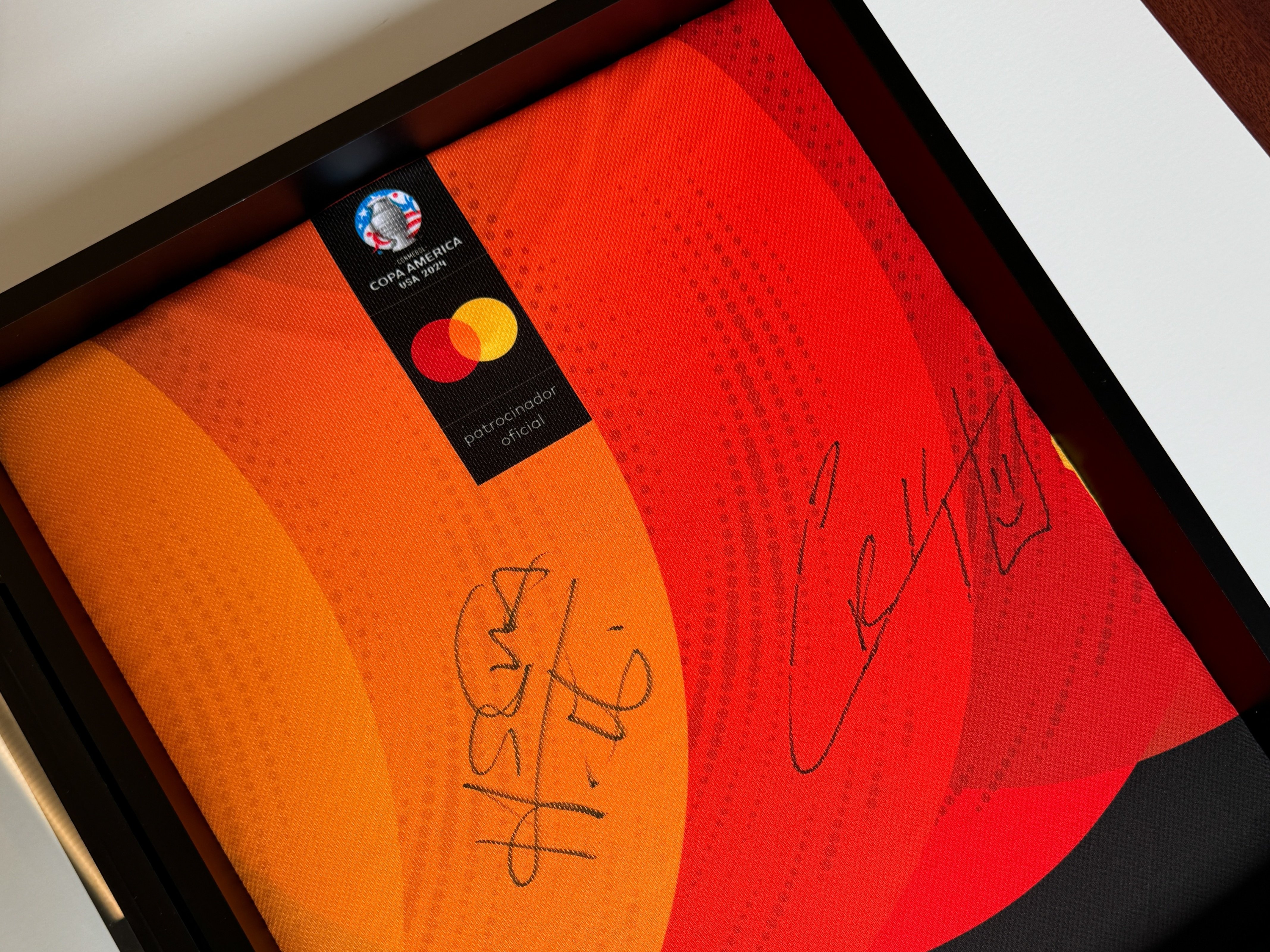 Close up photo of the signatures inside the picture frame.